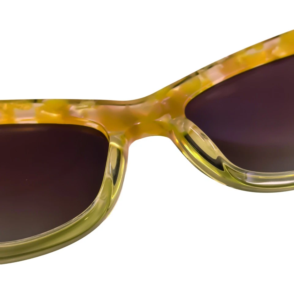 Close up of acetate frame texture and sharp cat eye silhouette on amber sunglasses Close up of acetate frame texture and sharp cat eye silhouette on amber sunglasses